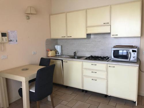 a small kitchen with a table and a microwave at Residence Il Vigneto in Oggebbio