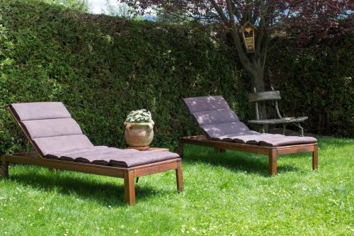 two chairs and a vase sitting in the grass at Landhaus Kirchmair in Telfes im Stubai