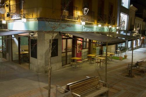 a bench in front of a building at night at Hostal Alcántara in Avila