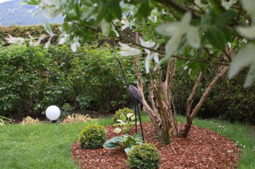 a garden with a tree and a white balloon at Landhaus Kirchmair in Telfes im Stubai