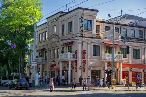 a building on a city street with people crossing the street at De Volan Boutique Hotel in Odesa