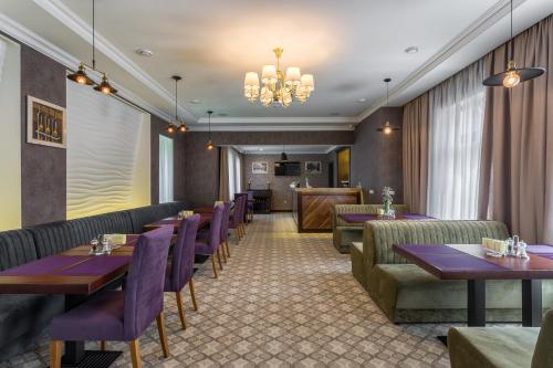 a restaurant with tables and chairs and a chandelier at De Volan Boutique Hotel in Odesa