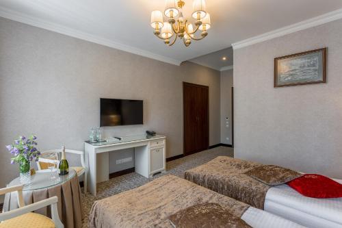 a hotel room with two beds and a desk at De Volan Boutique Hotel in Odesa