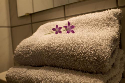 a stack of towels with purple flowers on them at Landhaus Kirchmair in Telfes im Stubai