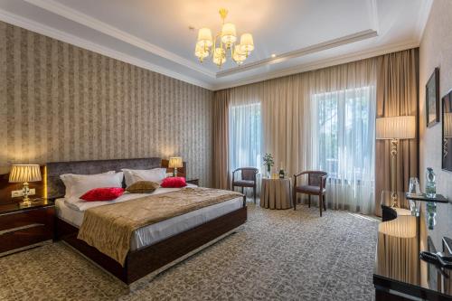 a bedroom with a large bed and a chandelier at De Volan Boutique Hotel in Odesa
