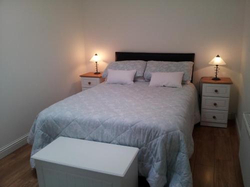 um quarto com uma cama grande e 2 mesas de cabeceira em Ashford Villa em Cong