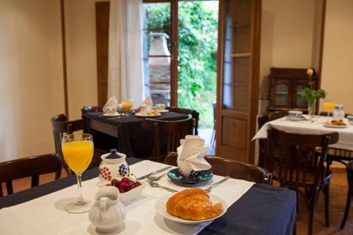 uma mesa com um prato de comida e um copo de sumo de laranja em Las Casonas de Avellaneda em Navia