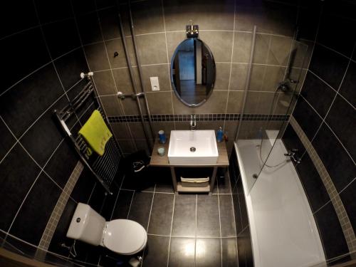 a bathroom with a sink and a toilet and a mirror at Heroes' Residence in Budapest