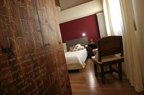 a bedroom with a bed and a wooden door with a chair at Bed & Breakfast Ai Cracchi in Castelgomberto