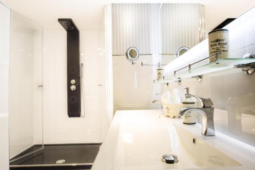 a white bathroom with a sink and a mirror at Luxuslodge Wernigerode in Wernigerode
