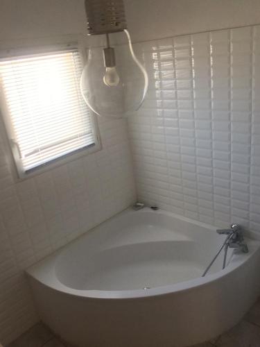 a white bath tub in a bathroom with a window at Clalou in Sérignan
