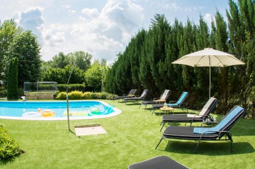 a group of chairs and an umbrella next to a swimming pool at Villa Oliva Boutique Rooms Zamárdi in Zamárdi