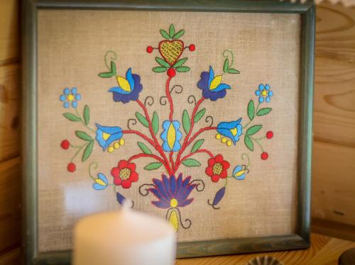 a picture of a flower painting with a candle at Sznureczki in Przewóz