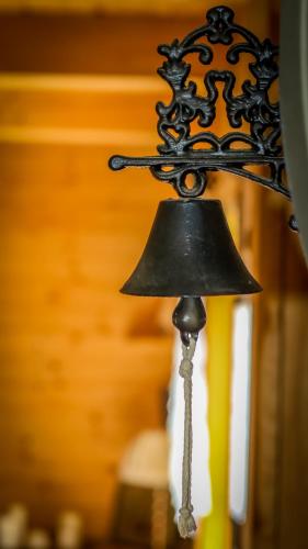 a bell hanging from a ceiling in a room at Sznureczki in Przewóz