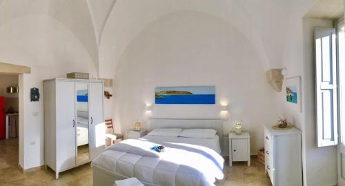 ポッジャルドにあるLa Loggia Salentinaの白いベッドルーム(ベッド1台、鏡付)