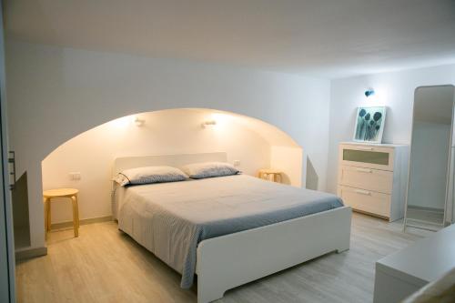 ナポリにあるLa Maisonetteの白いベッドとアーチ型の天井が備わるベッドルーム1室が備わります。