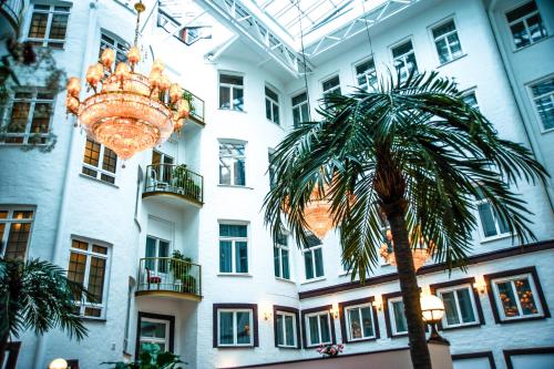 a chandelier and a palm tree in front of a building at Best Western Hotel Bentleys in Stockholm
