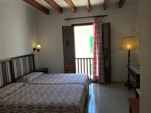 a bedroom with two beds and a window at Hostal Restaurante Playa in Colònia de Sant Jordi