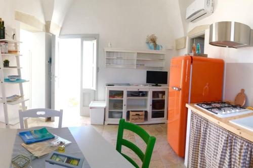 ポッジャルドにあるLa Loggia Salentinaのキッチン(オレンジ色の冷蔵庫、テーブル付)
