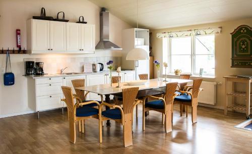 a kitchen with a dining room table and chairs at Tiendegaarden Møns Klint in Borre
