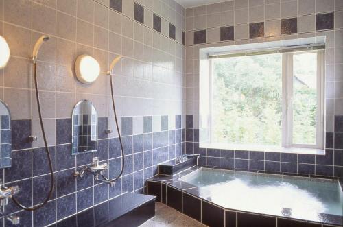 a bathroom with a tub and a window at Canari in Nasu