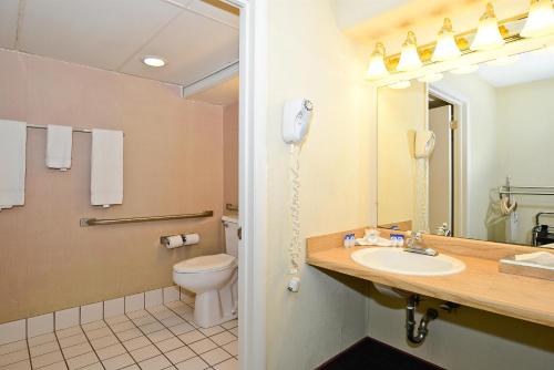 a bathroom with a toilet and a sink and a phone at Howard Johnson by Wyndham Benton Harbor in Benton Harbor