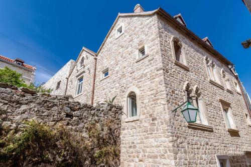 a stone building with a clock on the side of it at Heritage suites Zanini in Hvar