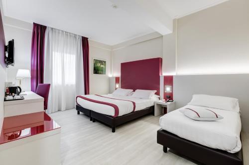 a hotel room with two beds and a desk at Best Western Hotel Rocca in Cassino