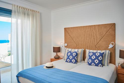 a bedroom with a large bed with a blue blanket at Nausicaa Luxury Villas in Protaras