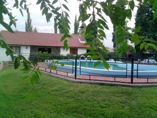 a fence around a swimming pool in front of a house at Cabañas Tunita´s in Coronel Suárez