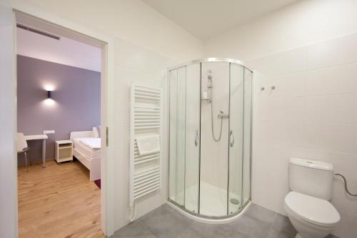uma casa de banho com um chuveiro e um WC. em Rozmaryn Rooms & Apartments em Rakovník