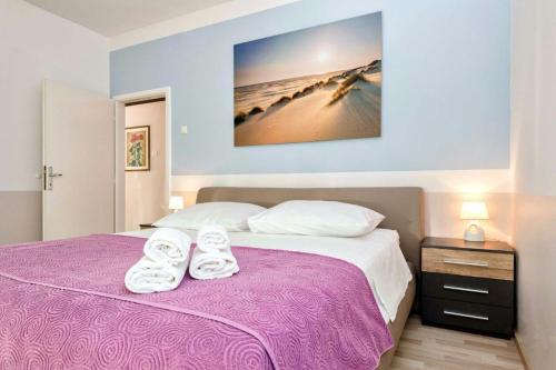 - une chambre avec un lit violet et des serviettes dans l'établissement Apartment Maja, à Split