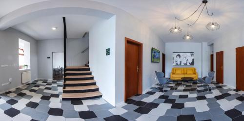 a hallway with a checkered floor and a yellow chair at Rozmaryn Rooms & Apartments in Rakovník