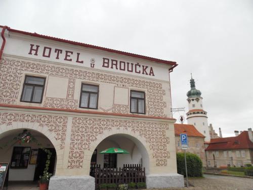a hotel building with a clock tower in the background at Hotel U Broucka in Nové Město nad Metují