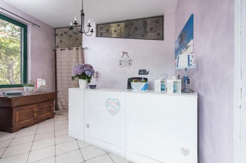 Un armario blanco en una habitación con flores. en Hotel La Villetta, en Fiumicino