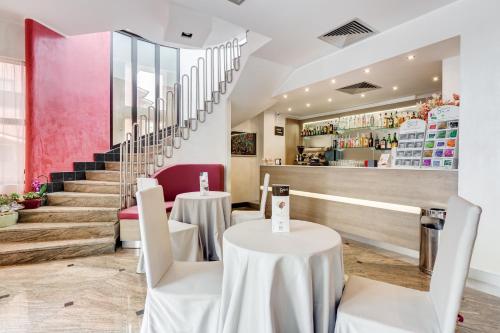 a restaurant with white tables and chairs and stairs at Best Western Hotel Rocca in Cassino