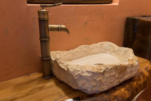 a stone sink in a bathroom with a pipe at Elpiniki in Alinda