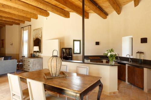une cuisine et une salle à manger avec une table en bois dans l'établissement Le Moulin de Pézenas - Pierres d'Histoire, à Pézenas
