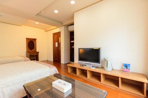 a bedroom with a bed and a tv on a table at Yosemite Homestay in Yuanshan