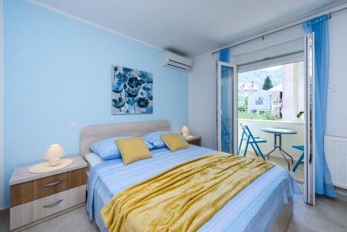 a blue bedroom with a bed and a window at Villa Ive in Mlini