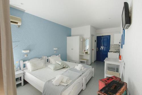 a bedroom with two beds and a blue wall at Nissos Poros in Poros