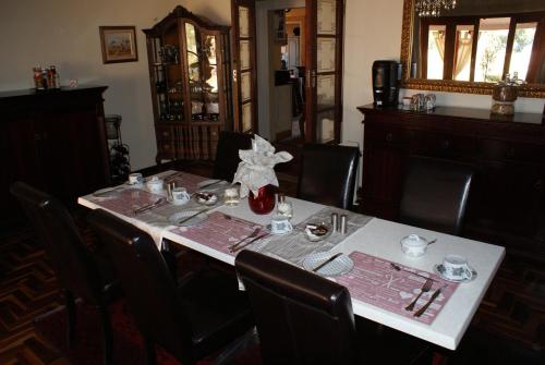 un tavolo in una sala da pranzo con una tavola apparecchiata per un pasto di Hampton House Guest House a Centurion