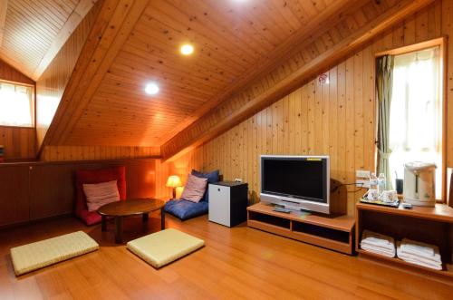 a living room with a flat screen tv in a cabin at Yosemite Homestay in Yuanshan