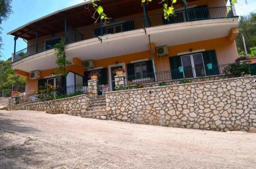 a building with a stone wall in front of it at Rania Apartments in Agios Nikitas