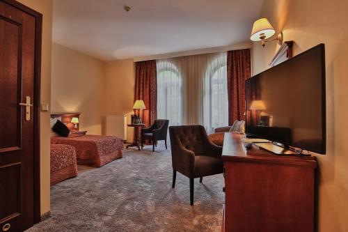 a hotel room with a large flat screen tv at Grand Hotel Stamary in Zakopane