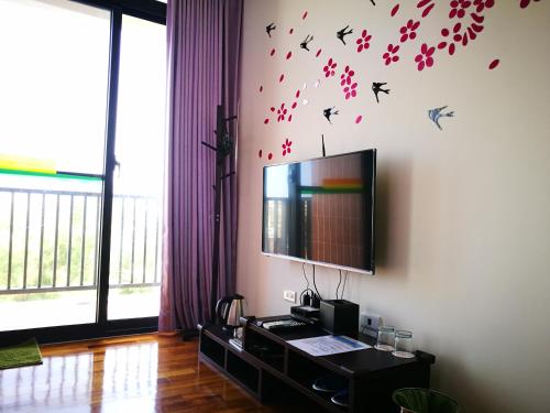 a living room with a tv and birds on the wall at 198紅帽民宿l市區l2025冷氣全面換新 in Magong