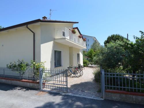 ein weißes Haus mit einem Zaun und Fahrrädern, die draußen geparkt sind in der Unterkunft Belvilla by OYO Venturi Olive in Gatteo a Mare