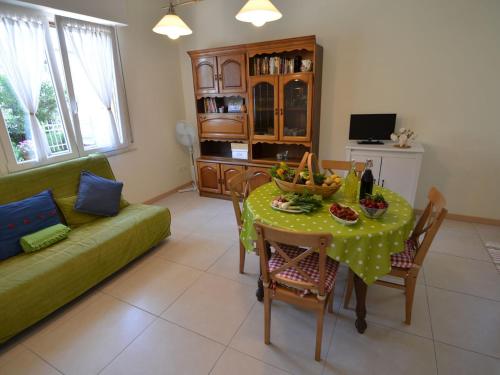 ein Wohnzimmer mit einem Tisch und einem grünen Sofa in der Unterkunft Belvilla by OYO Venturi Olive in Gatteo a Mare
