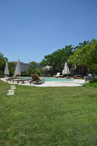 a swimming pool with tables and umbrellas on the grass at Palazzo Vecchio in Marittima