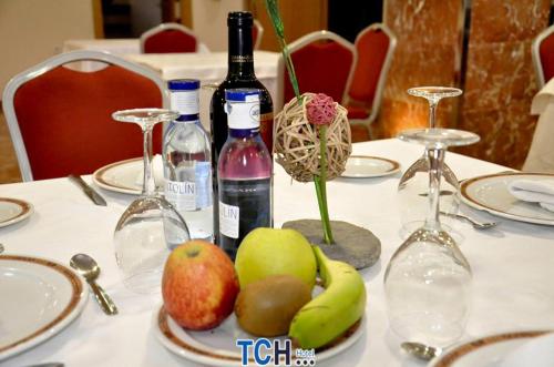 a table with a bottle of wine and fruit on it at TCH Hotel in Lorquí